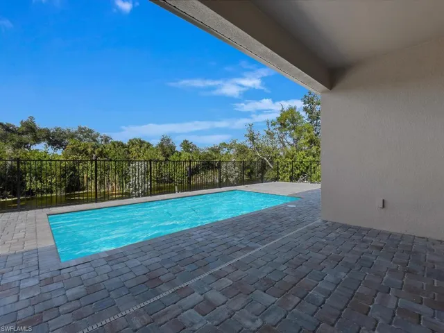 View of swimming pool featuring a fenced backyard and patio surround