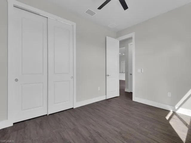 Unfurnished bedroom featuring dark wood finished floors, a closet, and ceiling fan