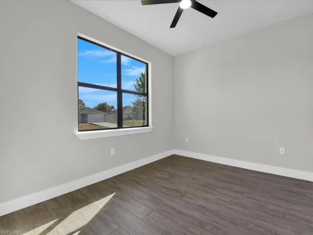 Unfurnished room featuring dark wood finished floors and a ceiling fan