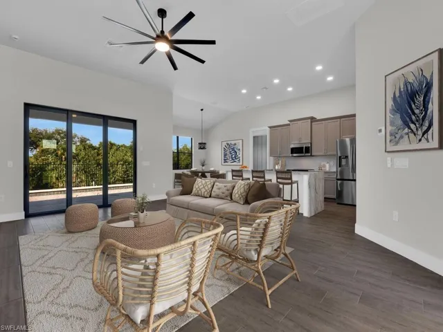 Living area featuring dark wood-type flooring, a ceiling fan, recessed lighting, and vaulted ceiling