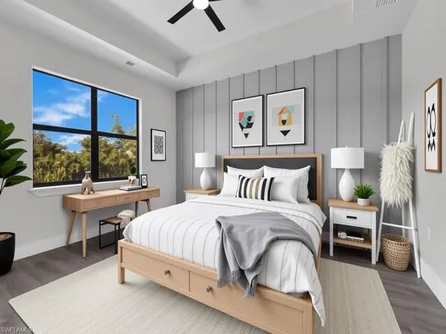 Bedroom with wood finished floors, an accent wall, and ceiling fan