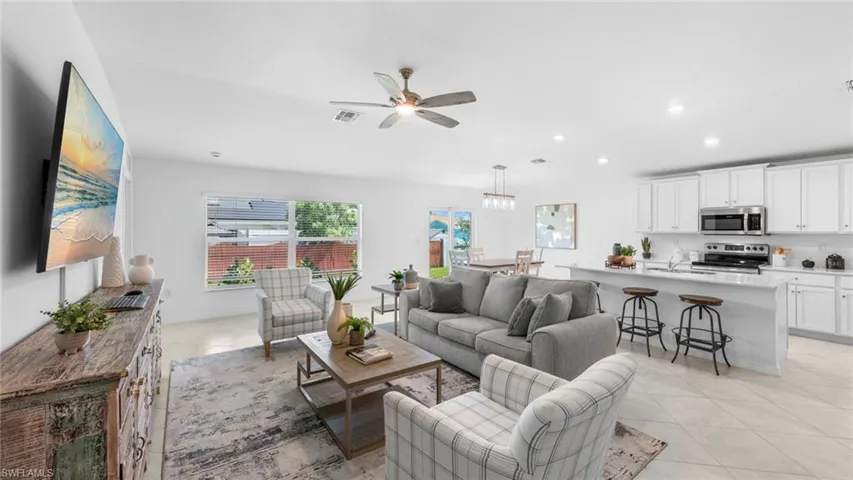 Living room featuring light tile patterned floors, a ceiling fan, and recessed lighting