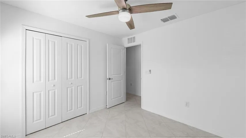 Unfurnished bedroom with a ceiling fan, a closet, and light tile patterned floors
