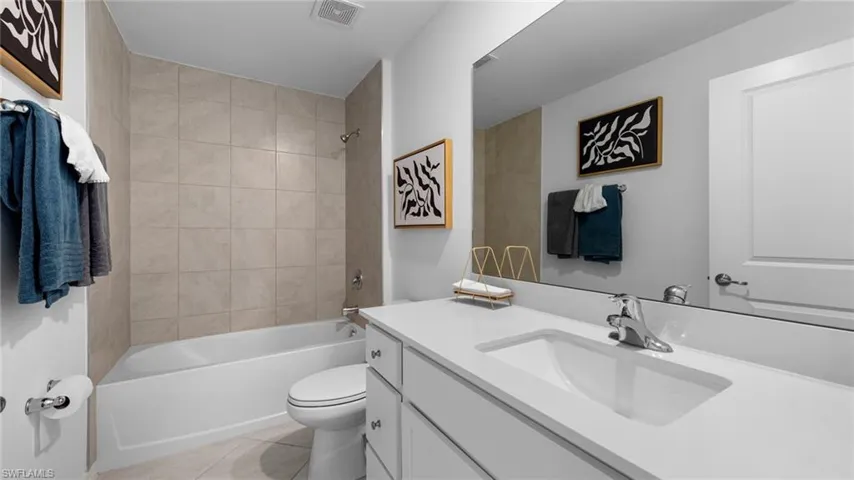 Full bath featuring shower / bathtub combination, vanity, and light tile patterned flooring