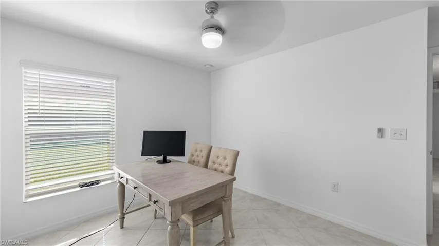 Office area with a ceiling fan and light tile patterned floors