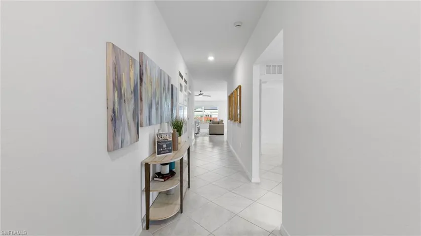 Hall with light tile patterned floors and recessed lighting