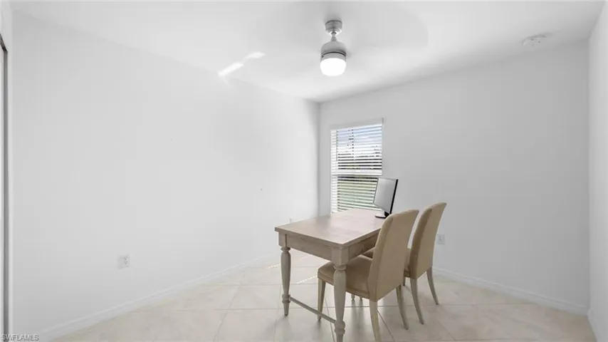 Office space with light tile patterned floors and ceiling fan