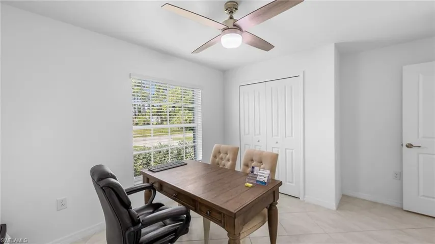 Office area with light tile patterned floors and ceiling fan