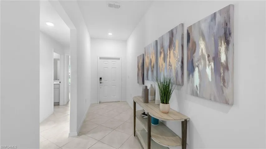 Hallway with light tile patterned floors and recessed lighting