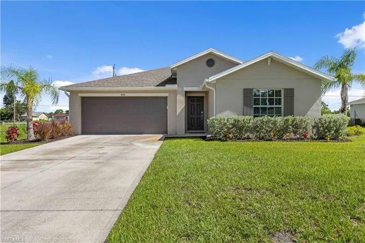 Ranch-style house featuring a garage, stucco siding, concrete driveway, a front yard, and roof with shingles