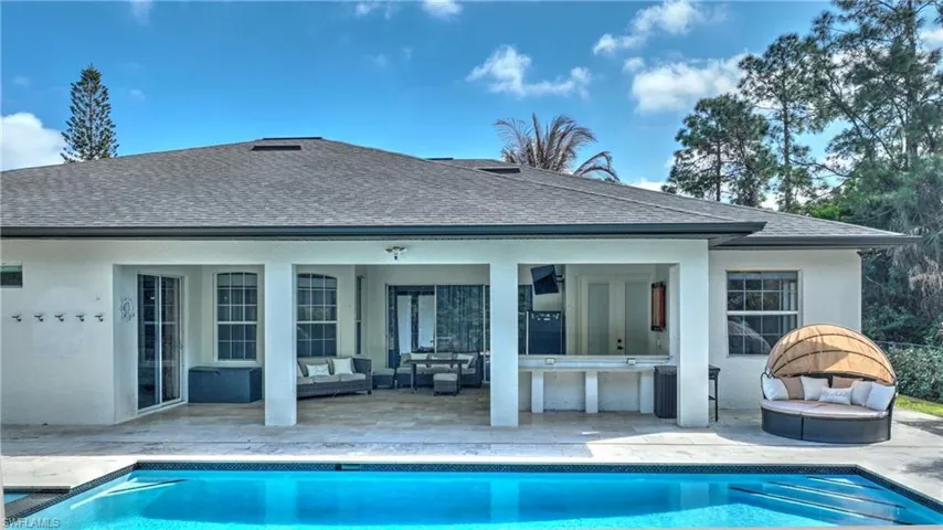 Rear view of house with outdoor lounge area, a patio area, and an outdoor pool