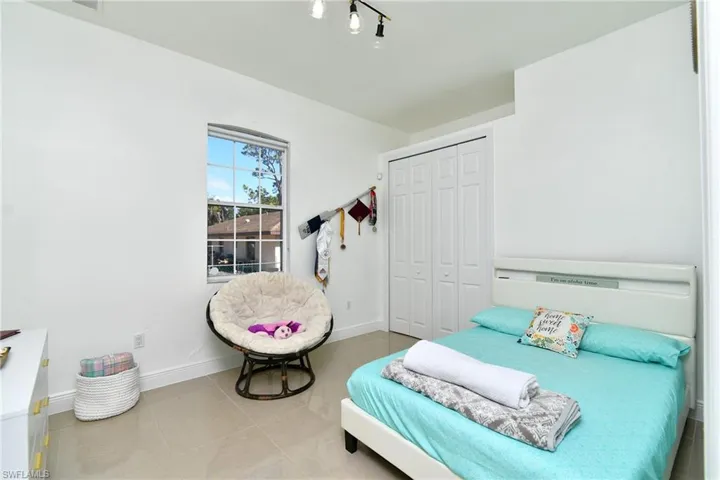 Tiled bedroom with a closet and baseboards