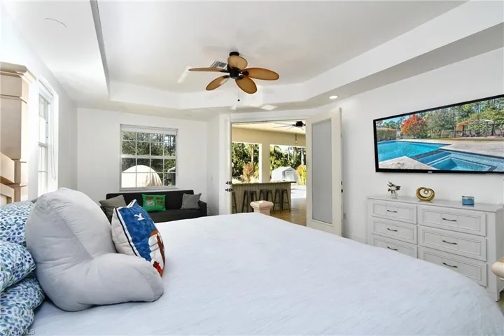 Bedroom with a ceiling fan and a tray ceiling