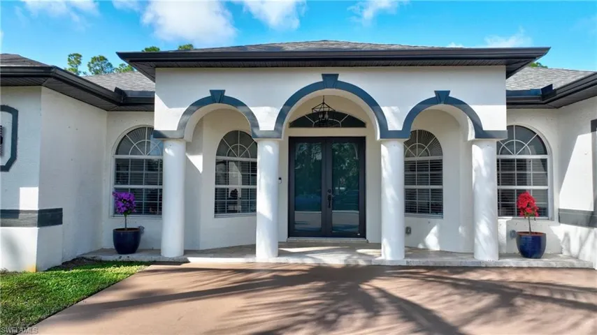 View of exterior entry with french doors, roof with shingles, and stucco siding