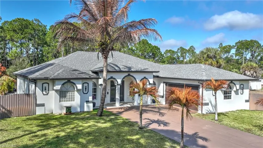 View of front of house with stucco siding, a shingled roof, concrete driveway, and an attached garage