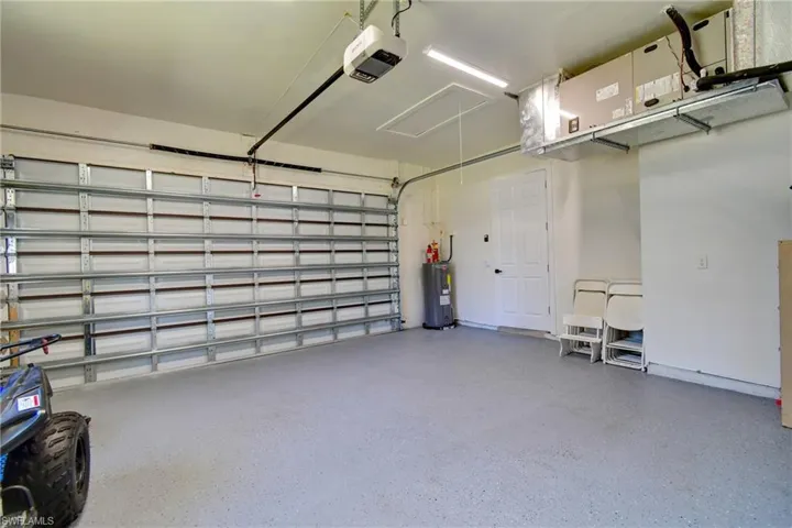 Garage featuring a garage door opener and water heater