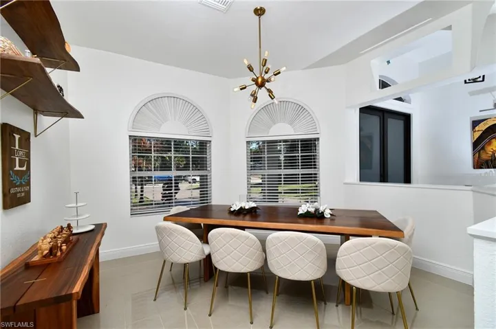 Dining space featuring light tile patterned floors and hanging lights