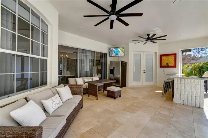 View of patio featuring an outdoor lounge area with bar, ceiling fan, french doors, and exterior kitchen
