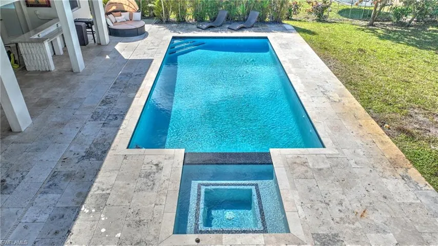 Swimming pool featuring an in-ground hot tub, a yard, and a patio