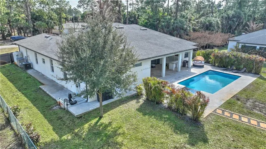 View of swimming pool with patio surround, a fenced backyard, and view of wooded area