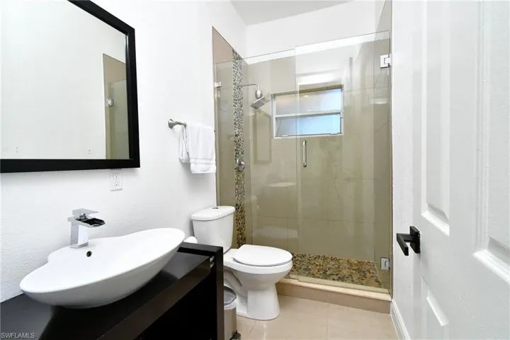 Bathroom with a stall shower, vanity, and tile patterned flooring