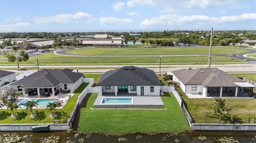 Aerial view of residential area featuring a large body of water and a pool area