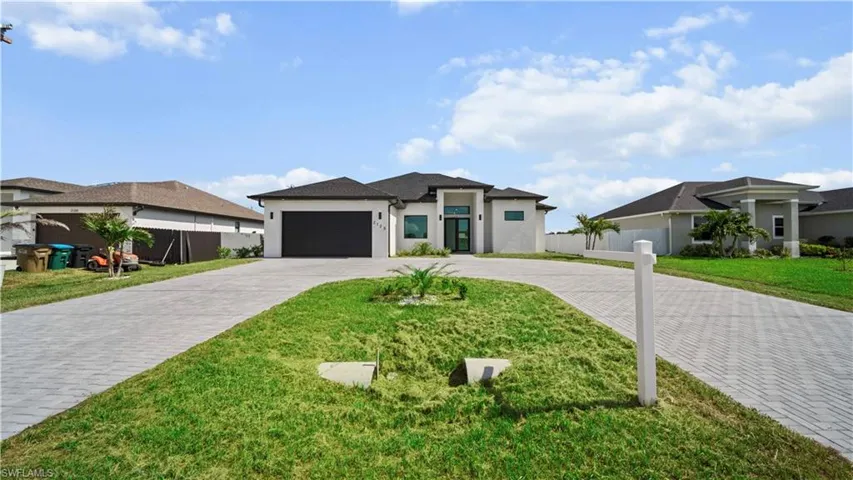 Prairie-style house with curved driveway, an attached garage, and stucco siding
