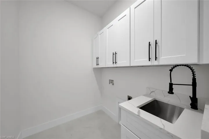 Laundry area with hookup for a washing machine, electric dryer hookup, and cabinet space