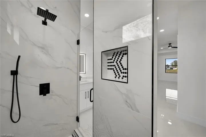 Full bathroom featuring recessed lighting, vanity, and a marble finish shower