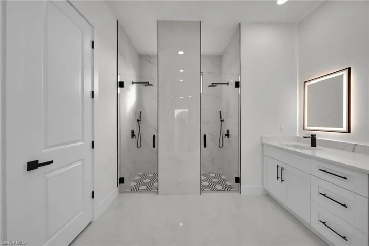 Full bathroom with a marble finish shower, vanity, and recessed lighting