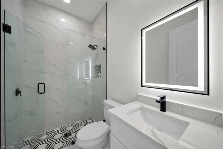 Full bath with vanity and a marble finish shower