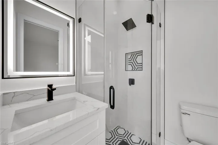 Bathroom with vanity and a marble finish shower