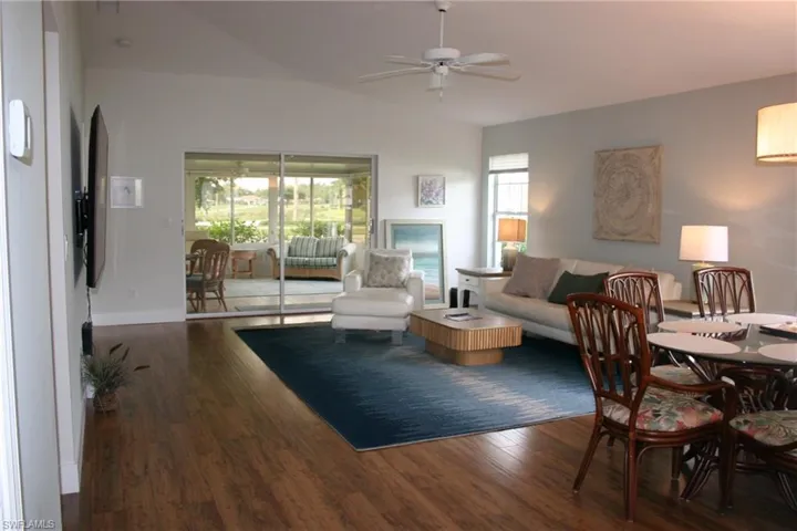 Wood-finish flooring throughout, vaulted ceiling, and sliding glass doors accessing a screened patio