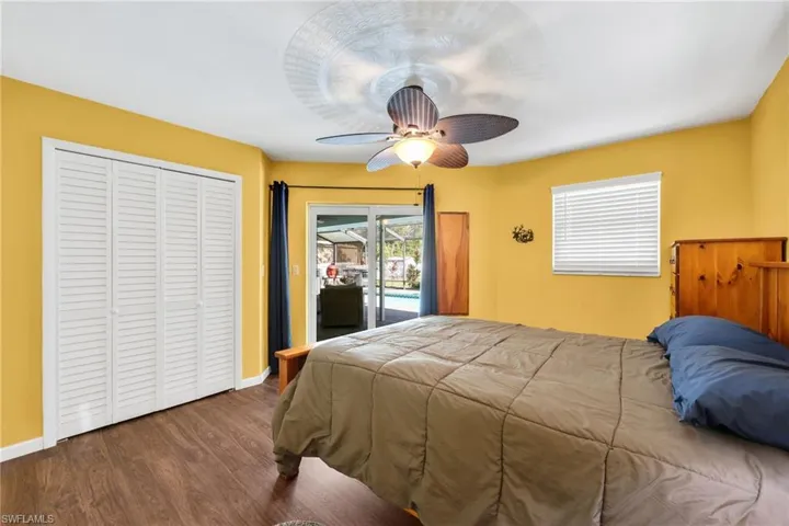 Bedroom featuring access to outside, wood finished floors, a closet, and ceiling fan