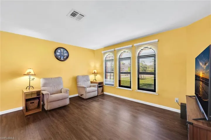 Sitting room featuring baseboards and dark wood-type flooring