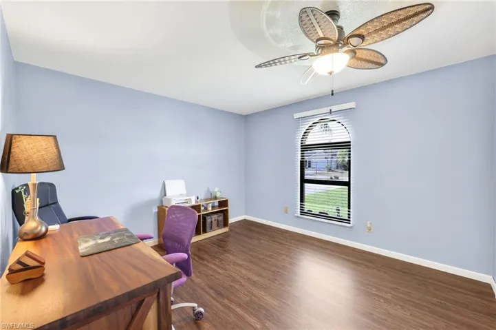 Office area featuring dark wood-style floors and a ceiling fan