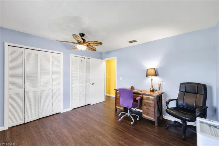 Home office featuring ceiling fan and dark wood-style flooring