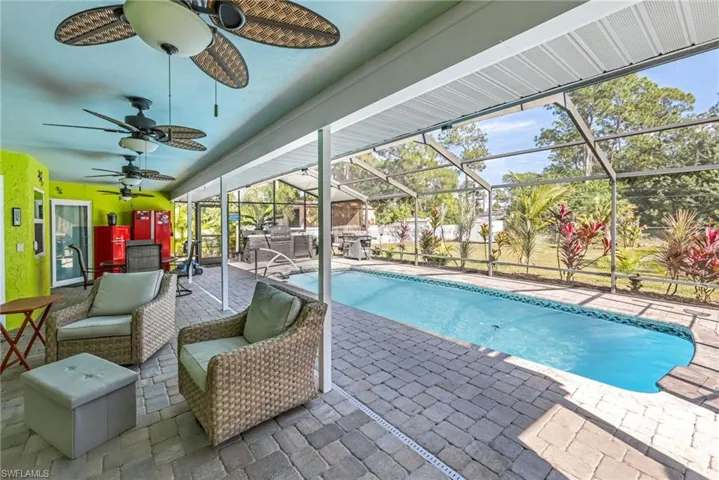 Swimming pool featuring a patio, glass enclosure, and a sunroom