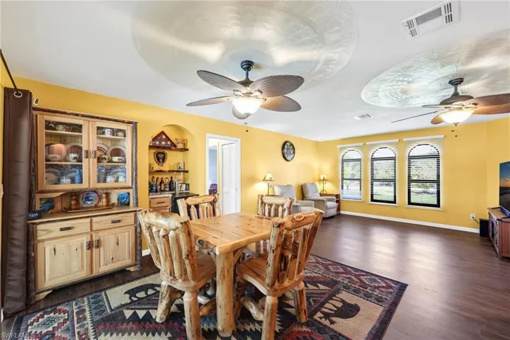 Dining space with dark wood-style flooring and ceiling fan