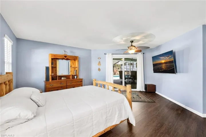 Bedroom featuring access to exterior, wood finished floors, and ceiling fan