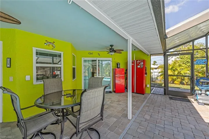 View of patio featuring ceiling fan, outdoor dining area, a lanai, and a sunroom