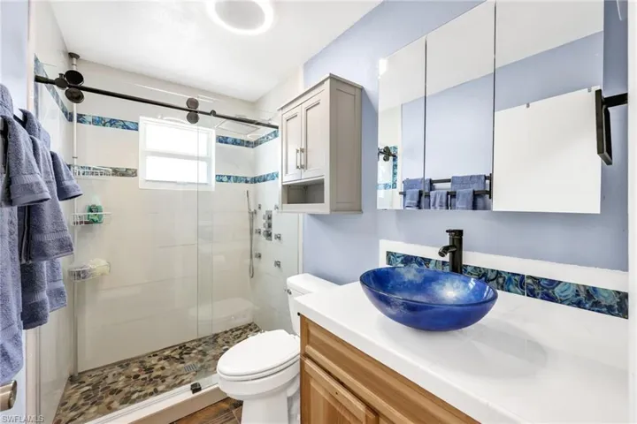 Full bathroom featuring vanity and a shower stall