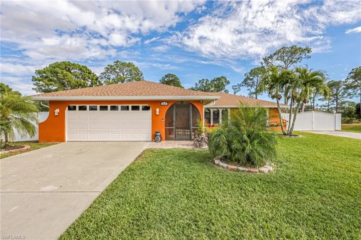 View of front facade with concrete driveway, a garage, a front yard, and stucco siding