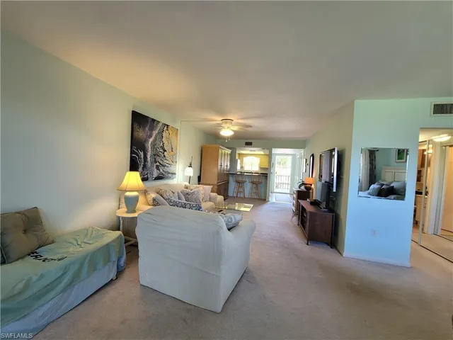 Living room with carpet floors and ceiling fan
