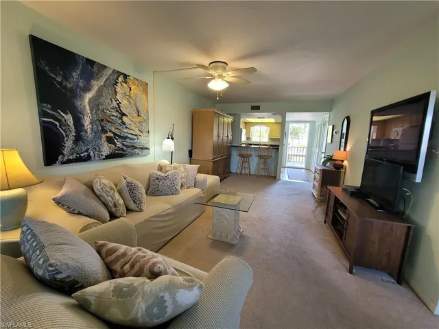 Living room featuring ceiling fan and carpet floors