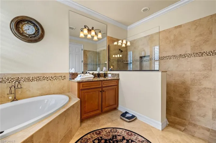 Bathroom with vanity, visible vents, ornamental molding, walk in shower, and a bath