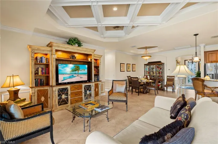 Living room featuring visible vents, crown molding, beamed ceiling, light tile patterned floors, and coffered ceiling