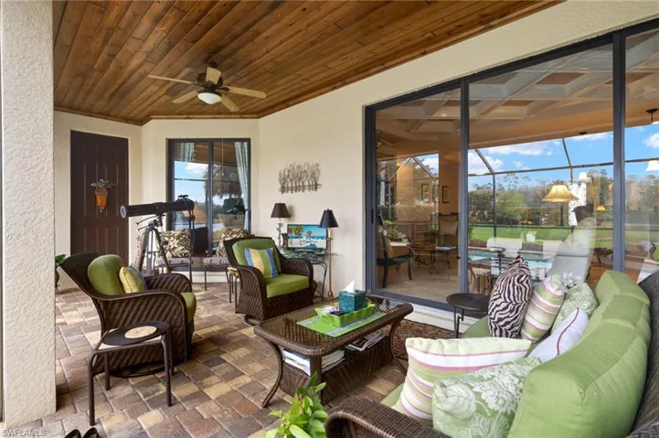 View of patio with glass enclosure, an outdoor hangout area, and a ceiling fan