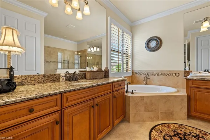 Full bathroom with a garden tub, ornamental molding, tile patterned flooring, tiled shower, and vanity