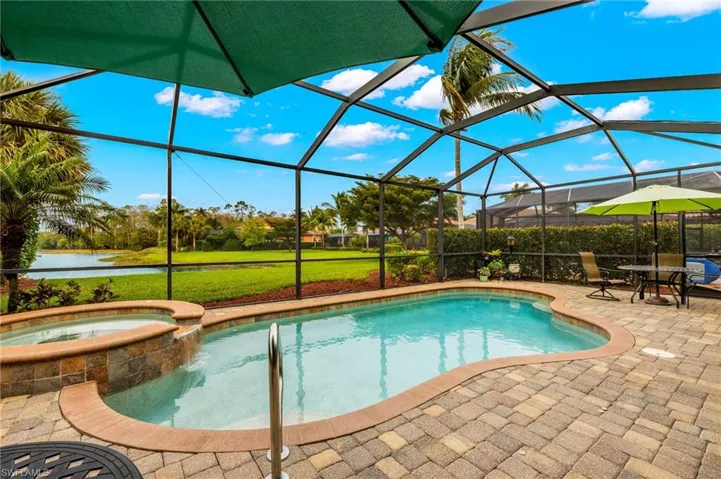 View of pool with a patio, a pool with connected hot tub, and a lanai